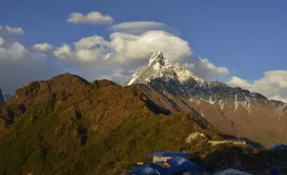 A breathtaking view of Machapuchare Mountain with its distinctive fishtail peak, seen during the Annapurna Base Camp Trek under clear blue skies.