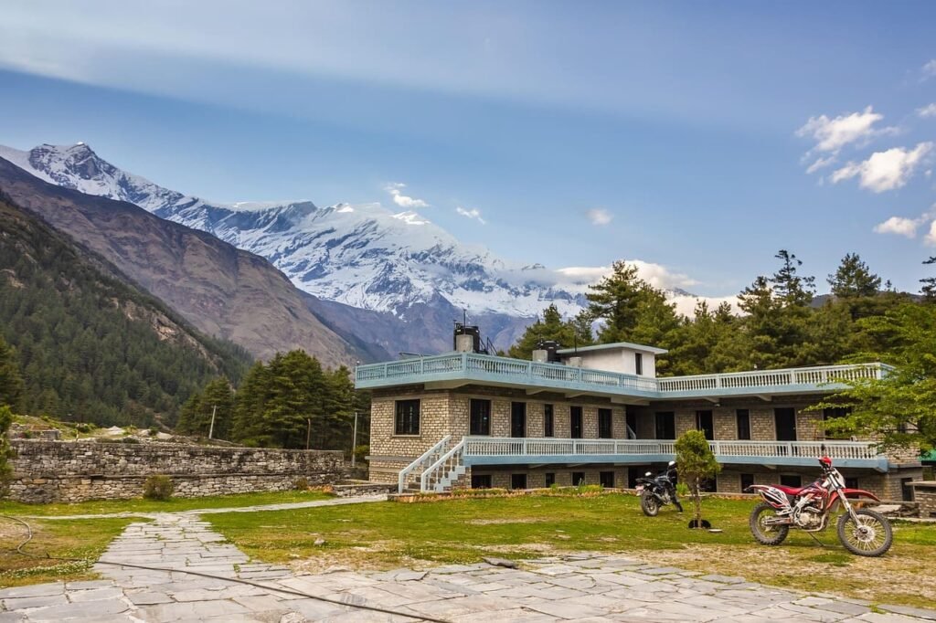 A cozy tea house nestled in front of the majestic Annapurna mountains, offering stunning panoramic views of the snow-capped peaks.